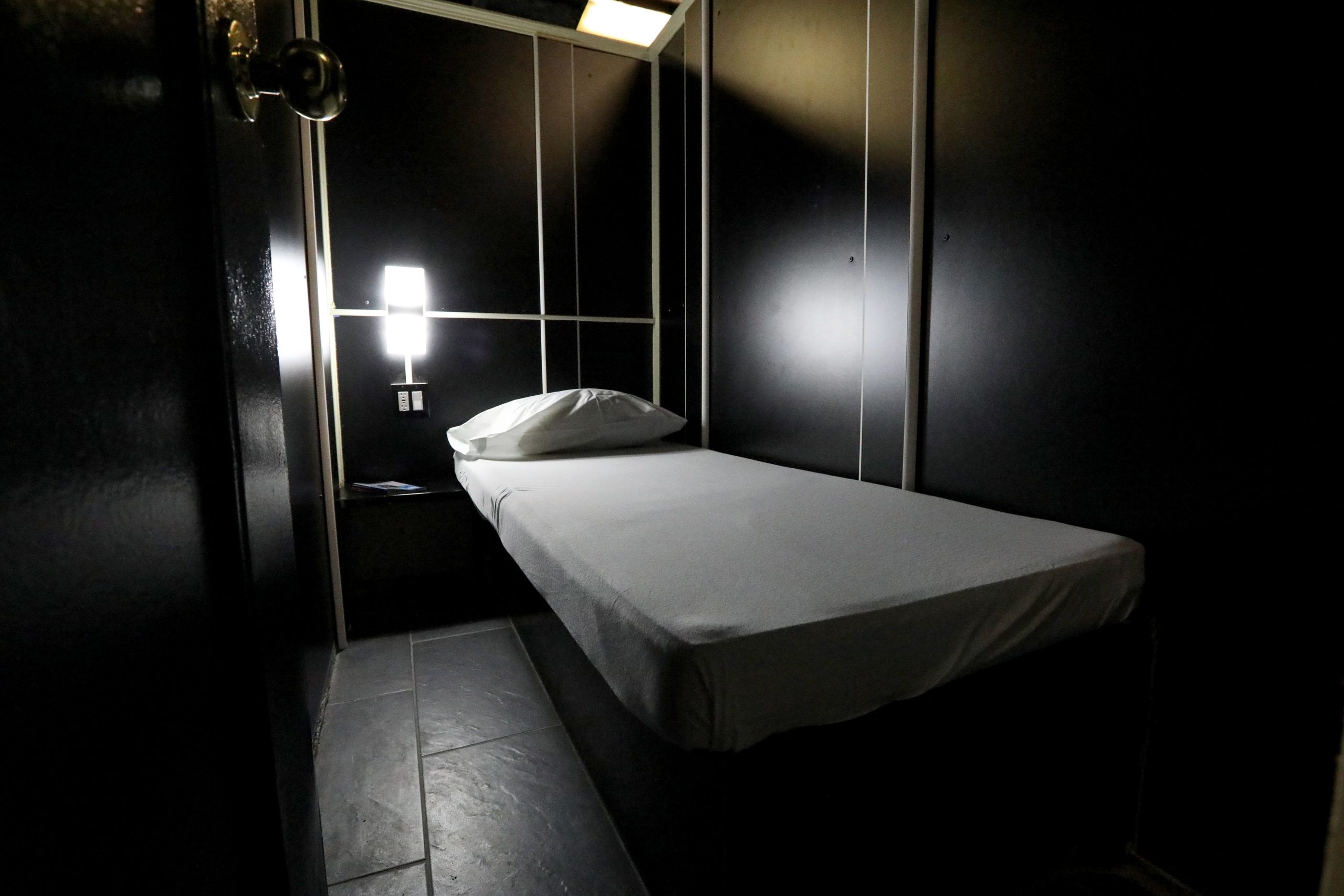 A private room at East Side Club with a made bed